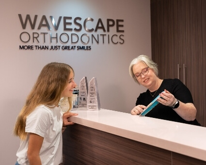 Wavescape Orthodontics receptionist assisting Dee Why patient with paperwork