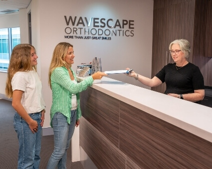 Receptionist discussing paperwork with patients