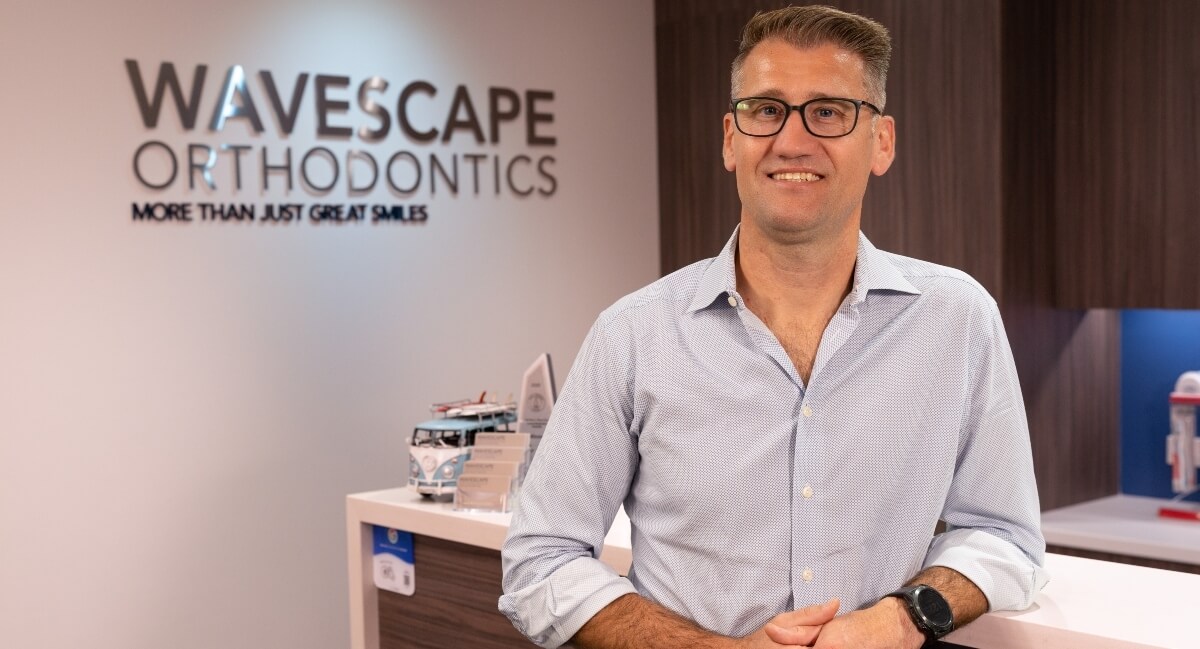 Dr Riaan Foot of Wavescape Orthodontics standing by desk