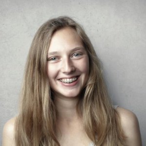Portrait of a happy young woman with braces smiling at the camera.