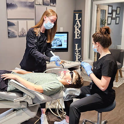 Doctor working with teen patient in dental chair