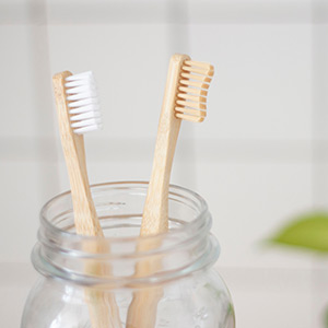 two toothbrushes in a glass jar