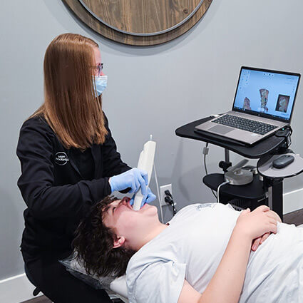 scanning patient's mouth with tool