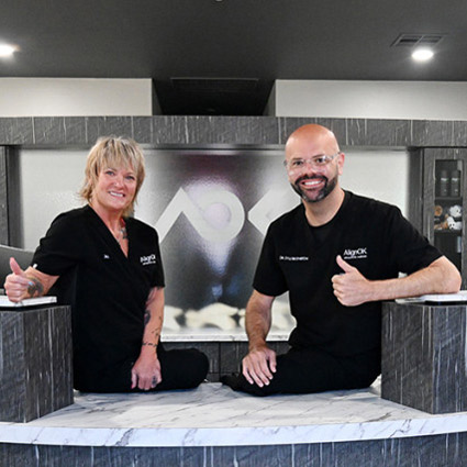 Doctor at front desk smiling thumbs up