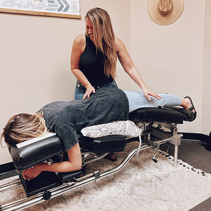 Dr-Kristin-smiling-adjusting-patient