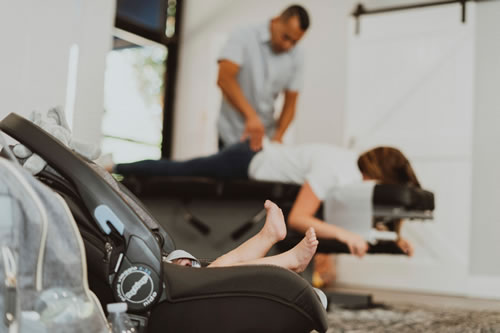 mom being adjusted while baby on trolly