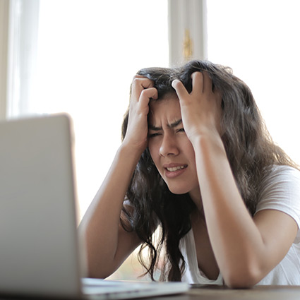 woman looking frustrated at her computer