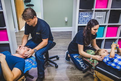 two chiropractors adjusting patients