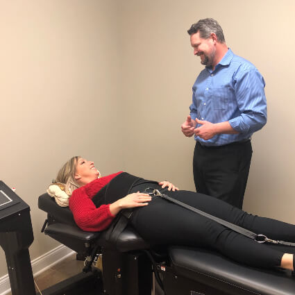 Murfreesboro chiropractor Dr Josh talking to patient on the decompression table