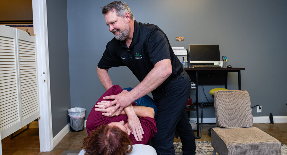 Murfreesboro chiropractor adjusting patient cross arm