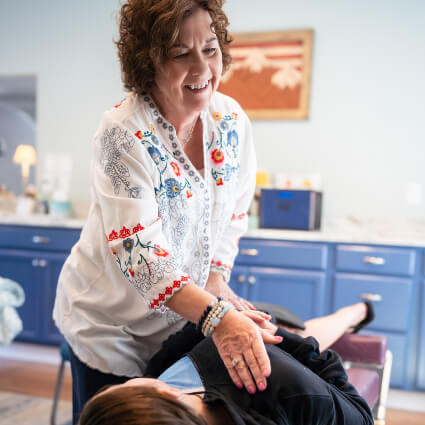 Smiling chiropractor adjusting a patient