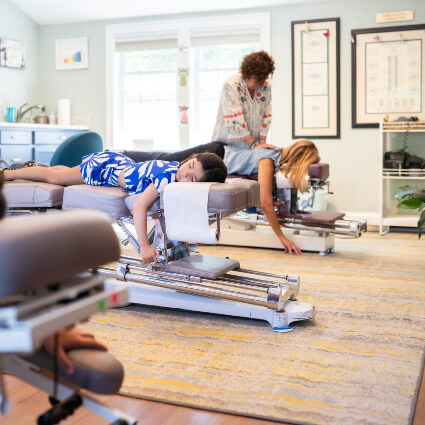 Mom and daughter receiving chiropractic adjustments