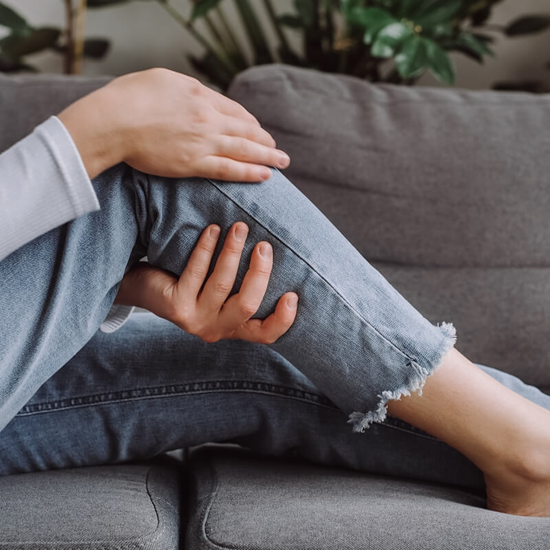 woman rubbing her lower leg