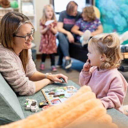 mom and kids playing with puzzles