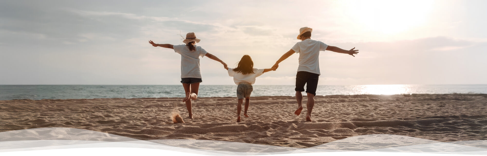 family of 3 running on the beach