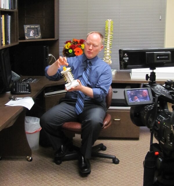 Houston chiropractor Dr. Minogue holding spinal model
