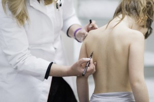 Physical therapist examining posture of a little girl