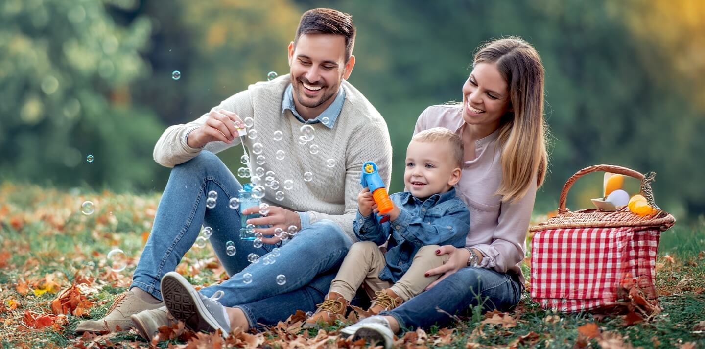 family playing bubbles at the park