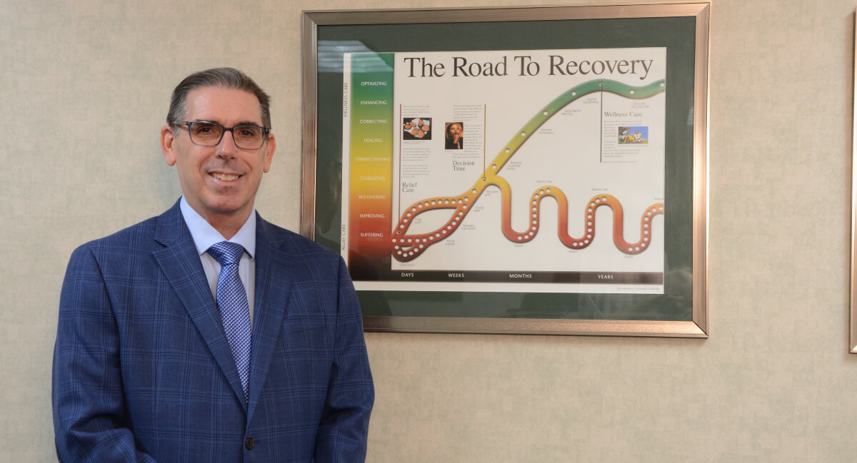 Dr. James O'Donahue standing next to framed poster