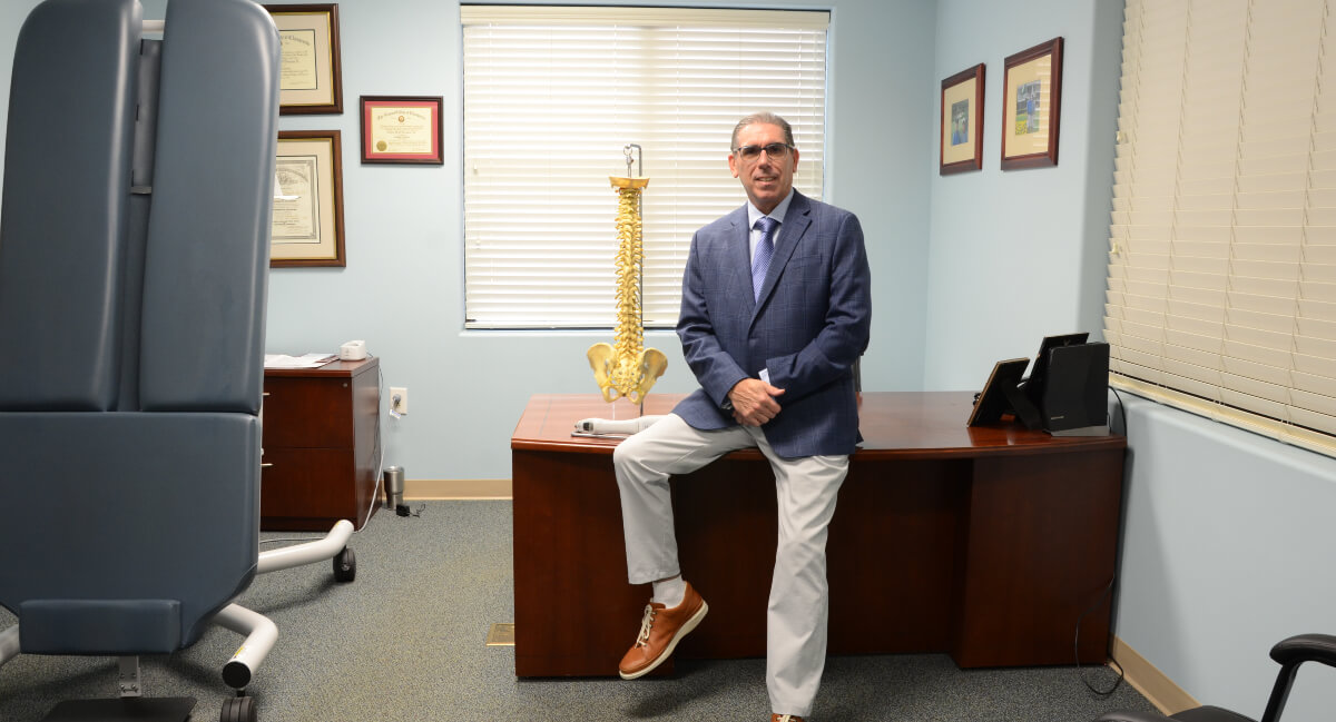 Greenville chiropractor Dr. O'Donahue sitting on office desk