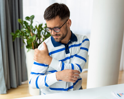 Young businessman with shoulder pain