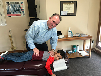 Dr. Maddigan adjusting a boy.