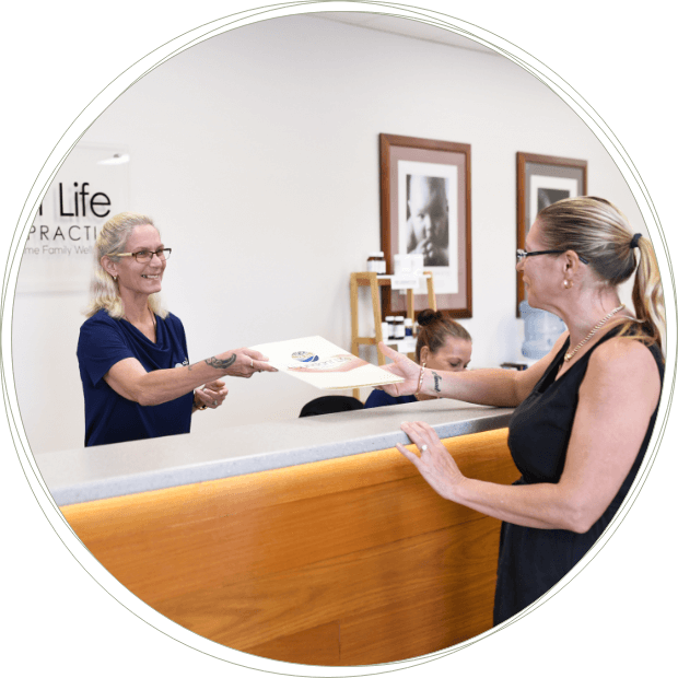 Abundant Life Chiropractic receptionist handing over paperwork to patient