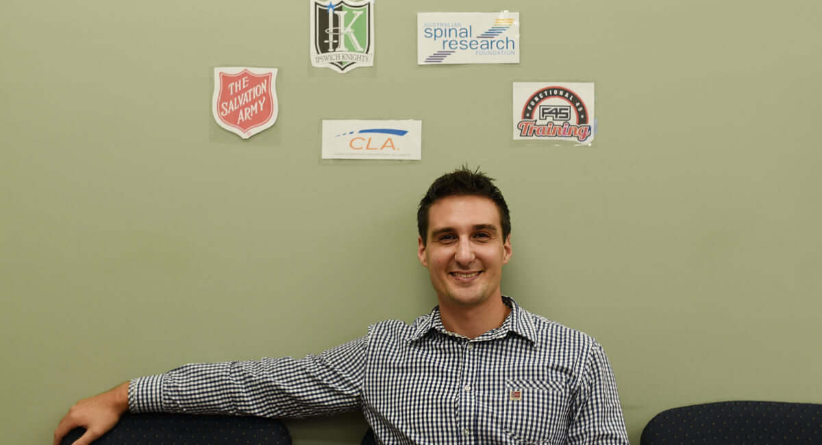 Dr. Nicj sitting with sponsor graphics behind him