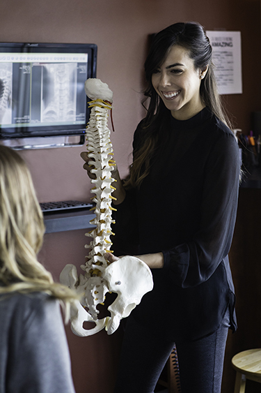 Woman holding a spine model