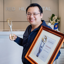 Dr Henry Ho holding awards