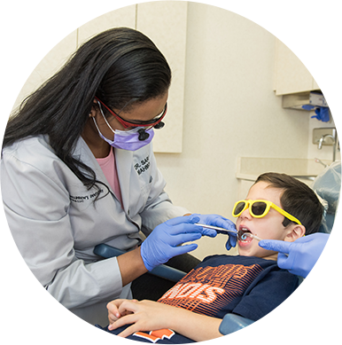 Dr Anu giving dental exam to little boy