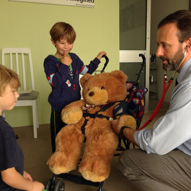 Dr Morick with young patients and a teddy bear
