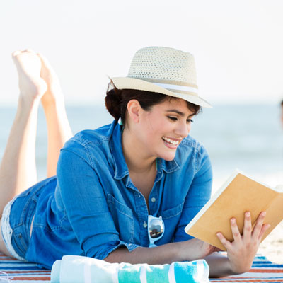 woman reading a book on the beach