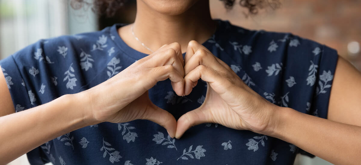 person making heart shape with hands