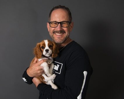 Dr. Jeff Koep of South Trail Chiropractic holding a dog
