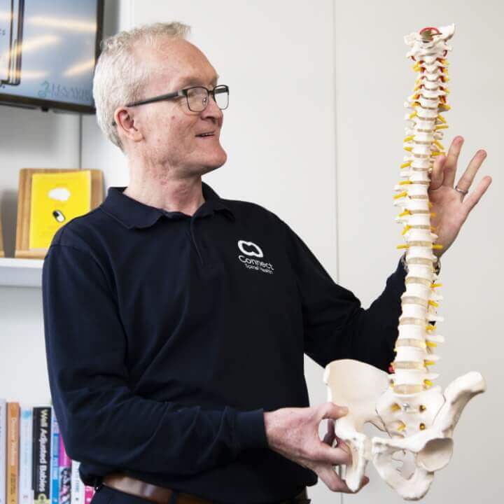 Dr. Andrew Feltoe holding spine model