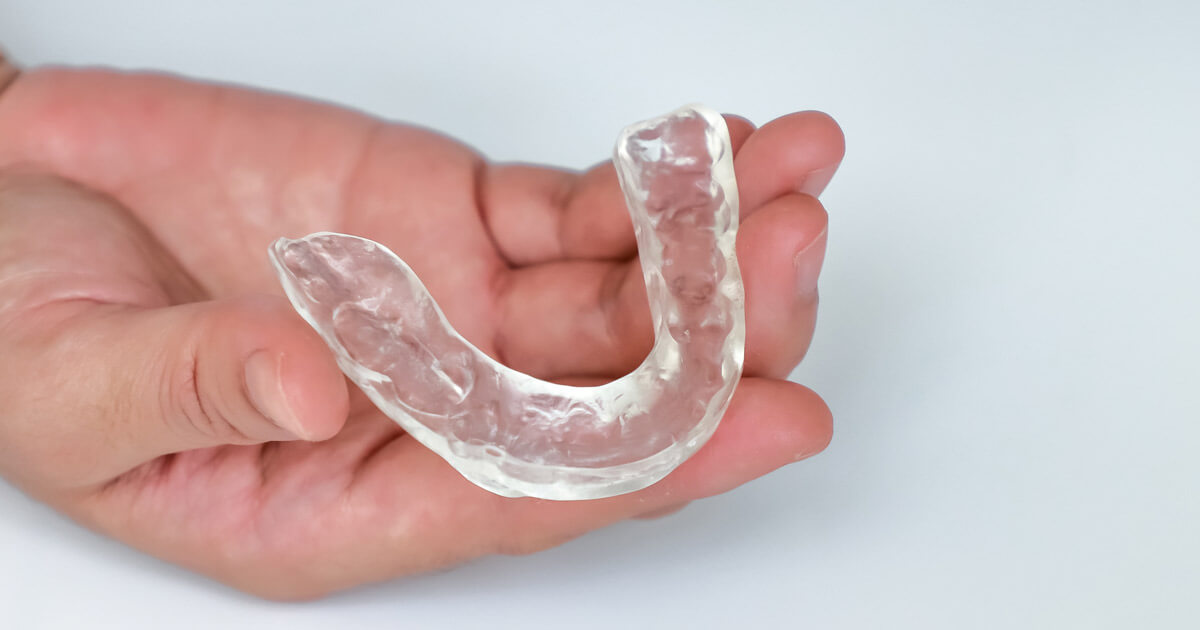 shutterstock image of hand holding mouthguard