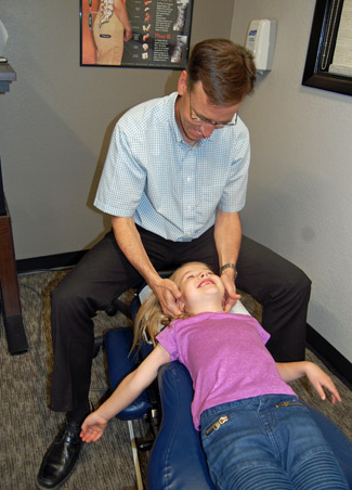 Dr. Bentley adjusting little girl