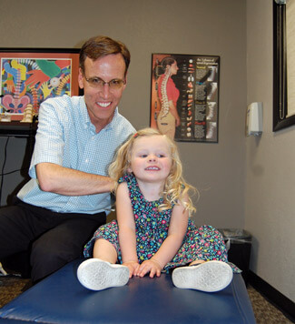 Dr. Bentley adjusting little girl