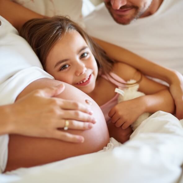 girl smiling with pregnant mom