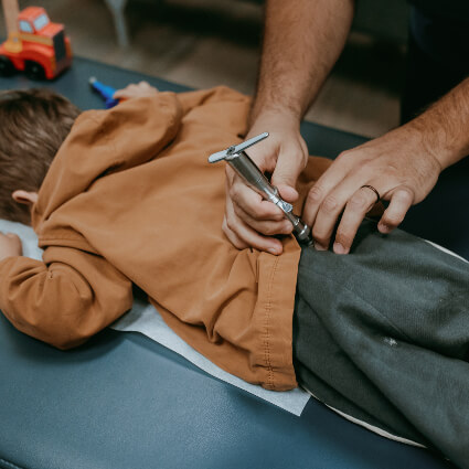 Pediatric Chiropractic activator on back