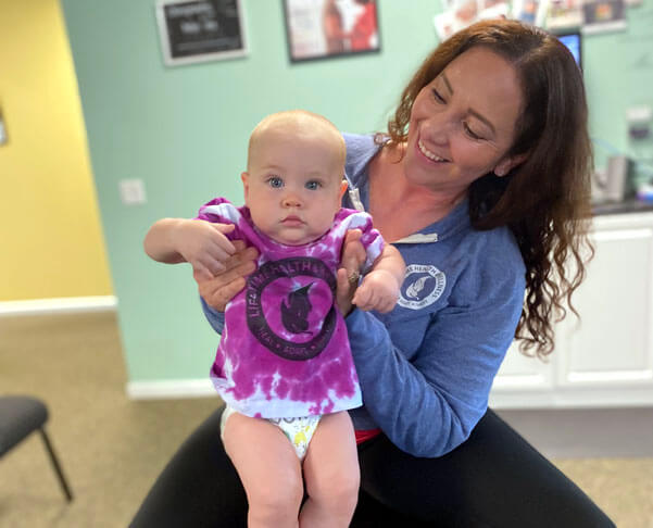 Naperville chiropractor holding a child patient
