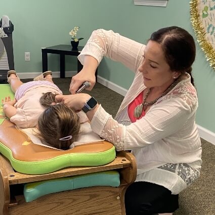 kid having neck adjusted with tool