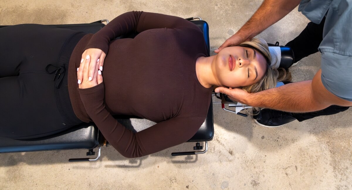 Chiropractor adjusting female patient's neck