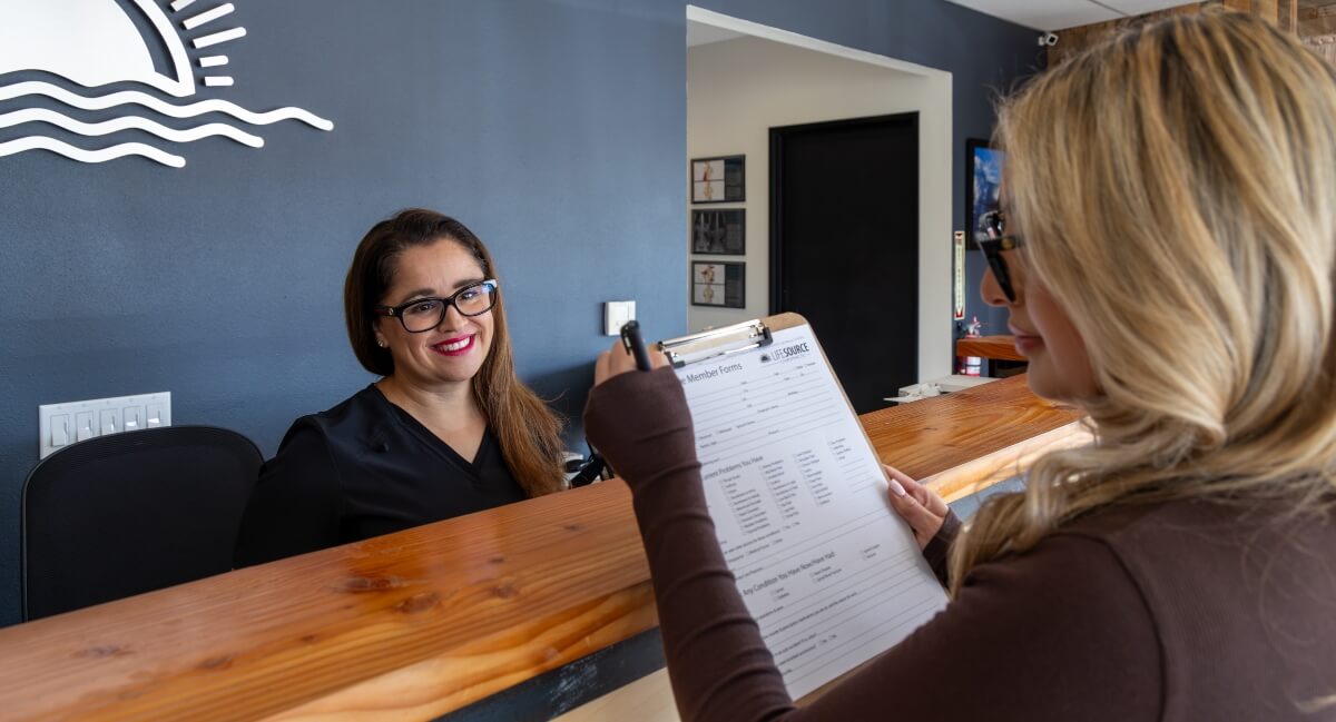 Receptionist and San Marcos patient discussing paperwork