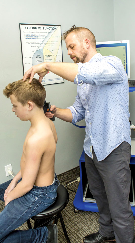 Dr. Krauza using adjusting tool on boy