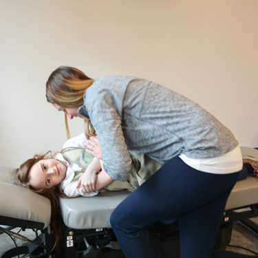 Dr. Amy adjusting a young girl