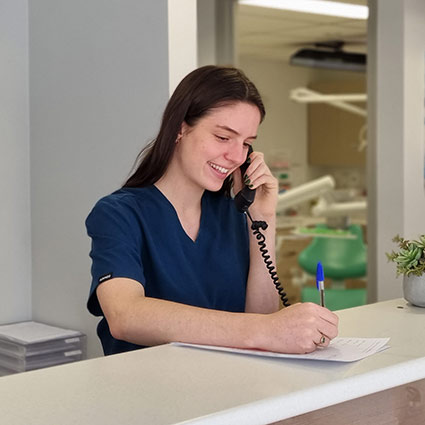 receptionist at front desk talking on phone