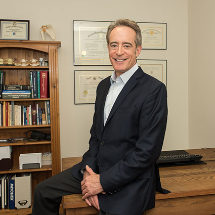 Dr. Taylor sitting on desk