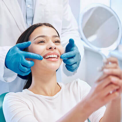 dentist-helps-woman-see-her-newly-whitened-teeth-sq